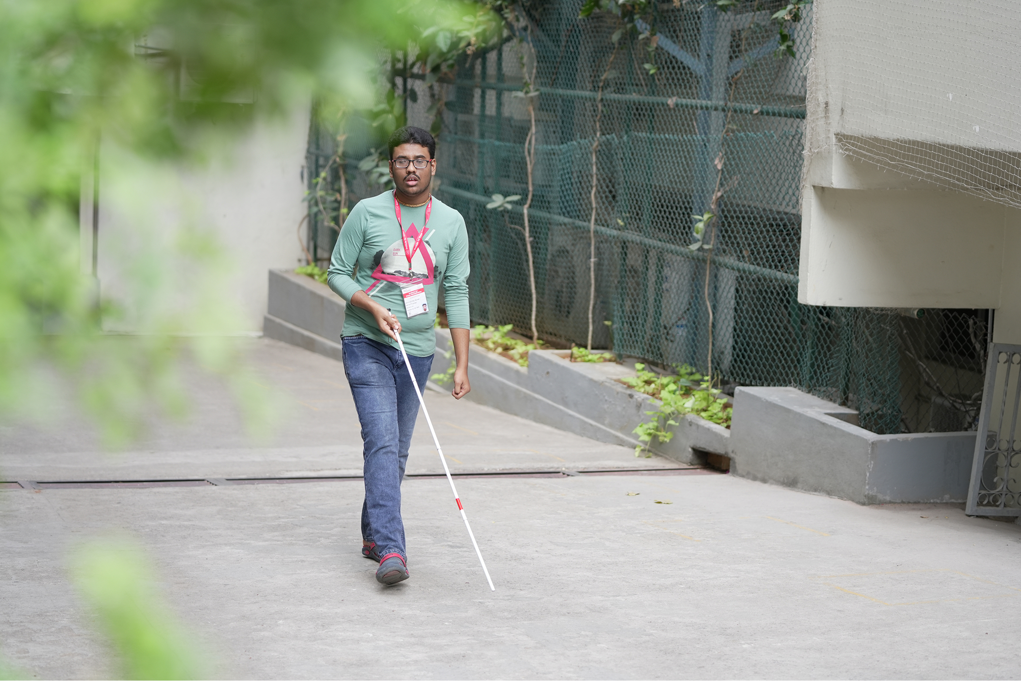 Young man walking with a white cane